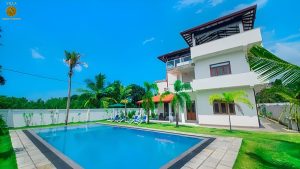 Villa Noble Horizon Sri Lanka – tropical villa garden with palm trees, sunbeds and outdoor relaxation area