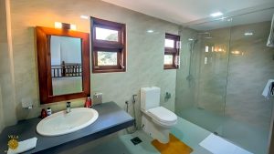 Villa Noble Horizon Sri Lanka interior – modern bathroom with sink, mirror, toilet and walk-in glass shower