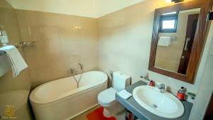 Villa Noble Horizon Sri Lanka interior – bathroom with bathtub, sink, mirror and toilet in bright tiled design