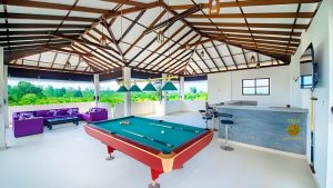 Villa Noble Horizon Sri Lanka – open rooftop lounge with billiard table, bar counter, and purple sofas overlooking tropical greenery