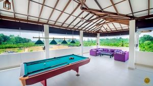 Villa Noble Horizon Sri Lanka – open rooftop lounge with billiard table, bar counter, and purple sofas overlooking tropical greenery