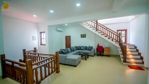 Villa Noble Horizon Sri Lanka interior – upstairs lounge with sofa corner, desk and wooden staircase